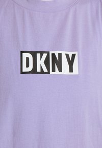 T-shirt di cotone viola chiaro con un logo rettangolare bianco e nero che presenta il testo "DKNY" in evidenza sul davanti.
