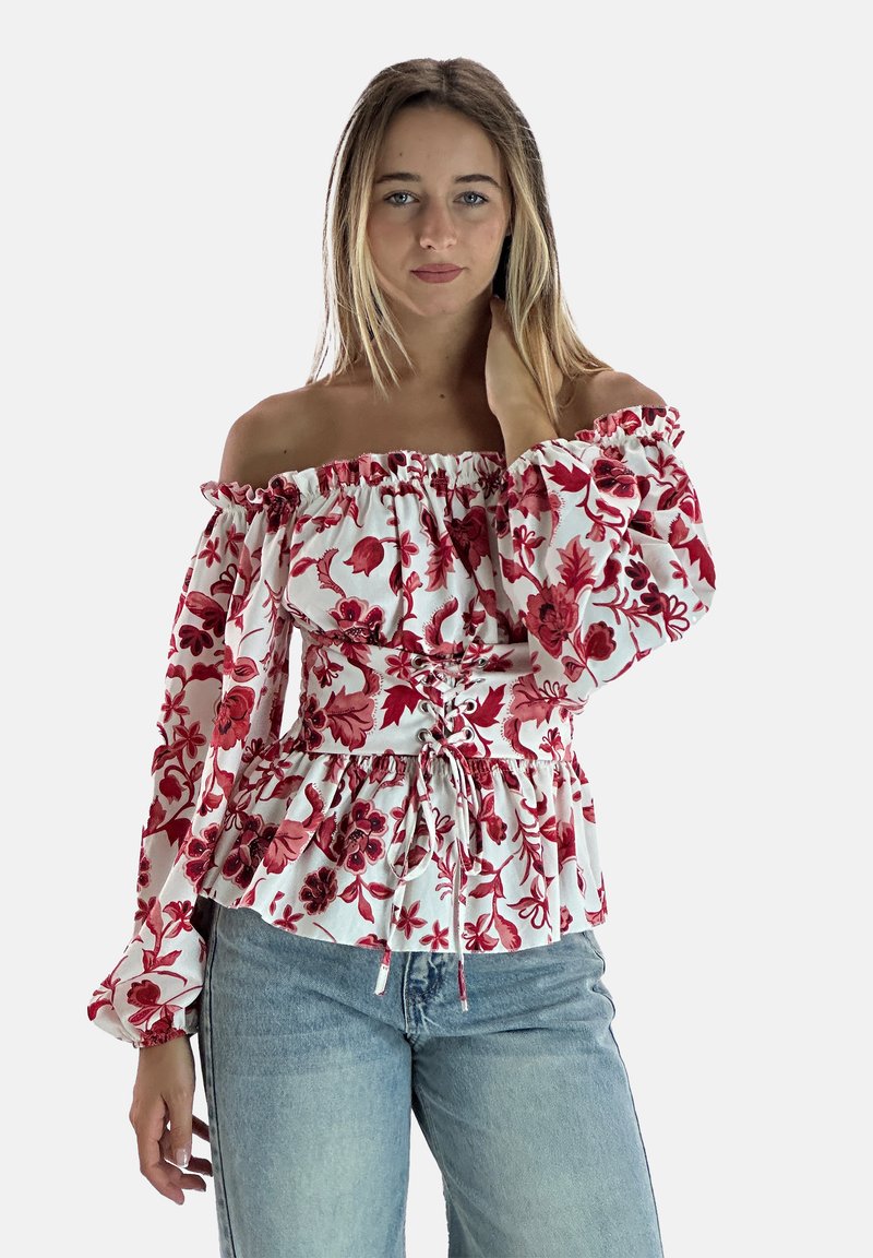 Hvid bluse med off-shoulder design og rød blomsterprint, elastisk rynket halsudskæring, indsnævret talje og peplum kant. Lange, flagrende ærmer.