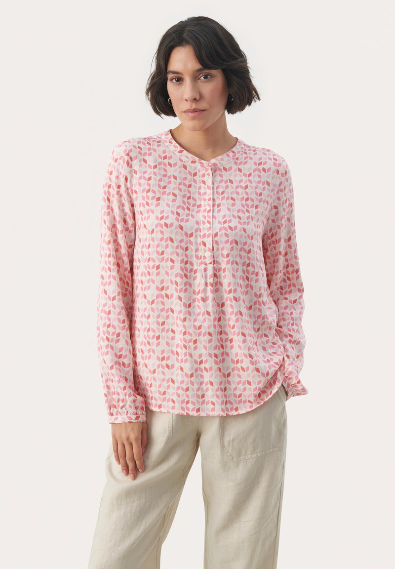 Ljusrosa långärmad blus med ett geometriskt bladmönster i mörkare nyanser av rosa, med rundad halsringning och knapprad.