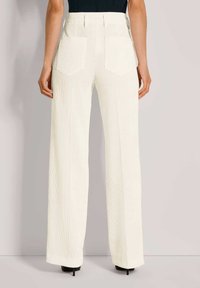 Witte geribde brede broek met een hoge taille, met twee achterzakken en een gladde textuur, getoond vanuit de achterkant.