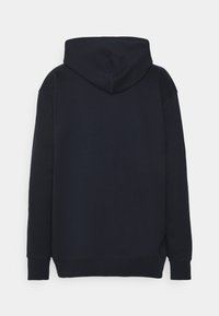 Sudadera azul marino con capucha ajustable, textura cepillada y puños y dobladillo acanalados. Presenta un corte holgado y sin logotipos ni acentos visibles.