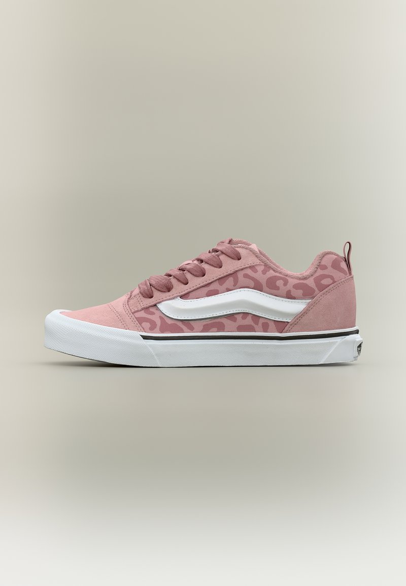 Ροζ αθλητικό παπούτσι χαμηλού τύπου με λεοπάρ σχέδιο, λευκή πλαϊνή ρίγα, λευκή λαστιχένια σόλα και ροζ κορδόνια σε ουδέτερο φόντο.