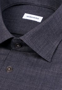 Chemise gris foncé à boutons avec col classique et étiquette indiquant "seidensticker" à l’intérieur du col.