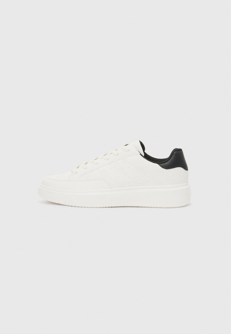 White leather sneaker with embossed pattern, textured white midsole, and black heel accent. Features rounded toe and flat laces.