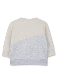 Sweatshirt beige clair et gris avec une surface texturée, un design en bloc de couleur courbé, des poignets et un ourlet côtelés, et un petit logo sur le côté.