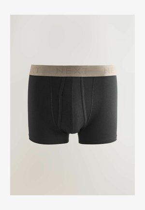 Svarta boxershorts med beige resårmidja med texten "NEXT." Försedda med en framficka och ett mjukt tyg.