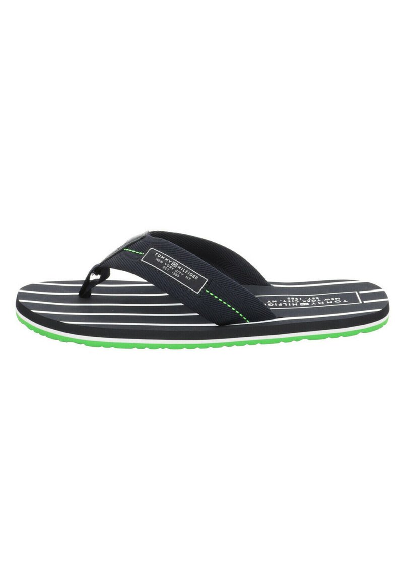 Chanclas navy con rayas horizontales blancas, suela verde y correas negras texturizadas que presentan un parche de logo y costuras en contraste.
