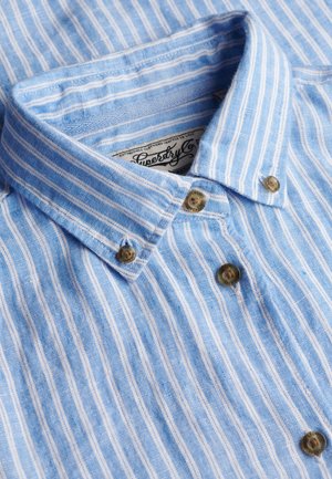 Colletto di camicia a righe verticali blu e bianche con bottoni marroni e etichetta del marchio Superdry visibile all'interno del colletto.