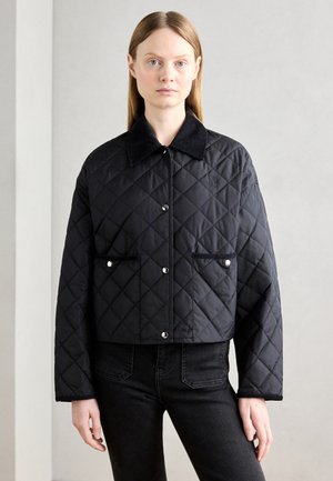 Veste cropped noire matelassée avec un col, des boutons-pression et deux poches avant. Présente une texture de tissu douce et un logo subtil.