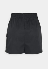 Svarta shorts i slätt material med elastisk midja. Har sidofickor och en avslappnad, rak skärning.