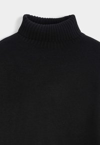 Pull à col roulé noir avec un col haut côtelé. Tissu en maille douce avec une texture lisse. Aucun motif ou détail métallique visible.