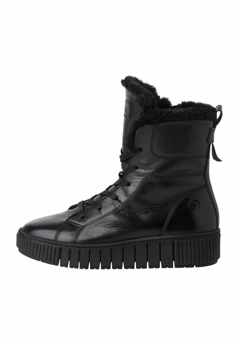 Botte montante en cuir noir avec semelle épaisse rainurée et doublure en fourrure noire visible autour de la cheville et de la languette, lacée à l'avant.