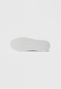 Λευκή εξωτερική σόλα αθλητικού παπουτσιού με σχέδιο ψαροκόκκαλο, λείες άκρες και καμπύλη φτέρνα, κατασκευασμένη από καουτσούκ.