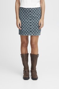 Kratka denim krilo s karo vzorcem v sivih odtenkih, obliko prilegajoča, dolžina do sredine stegna, v kombinaciji z rjavimi škornji do kolen z zaponkami.
