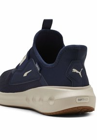 Sneaker navy con tomaia in mesh strutturato, suola beige chiaro e marchio Puma. Presenta un tassello per il pollice e un design della intersuola ammortizzata.