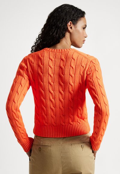 Narancssárga kötött pulóver bordázott szegéllyel és mandzsettával, texturált mintával. A hátulnézet az aprólékos hímzés részleteit mutatja.