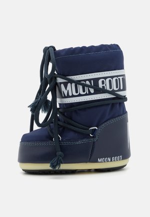 Water-resistant navy blue Moon Boot with a padded upper, contrasting white logo, laces, and a textured rubber sole for traction.