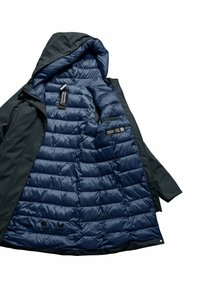 Gevoerd jack met een donkergroene buitenkant en marineblauwe binnenvoering. Voorzien van een capuchon, ritssluiting en binnenzakken. Labels zichtbaar aan de binnenkant.