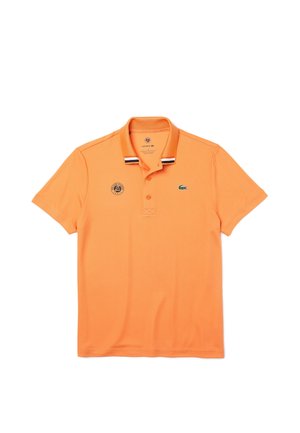 Pomarańczowa polo z krótkim rękawem z prążkowanym kołnierzykiem w czarno-białe paski, trzy guzikowy dekolt, oraz małe logo na piersi.