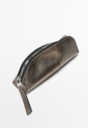 Metallic bronzefarbene Federtasche mit strukturierter Oberfläche, ausgestattet mit einem schwarzen Reißverschluss und einem kleinen Lederzieher. Schlanke, längliche Form.