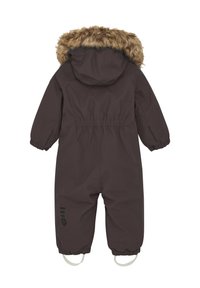 Mörkbrun isolerad sn overall med en huva klädd i fuskpäls, elastiska ärmmuddar och bottenremmar för att fästa vid kängor. Har en logotypdetalj på benet.