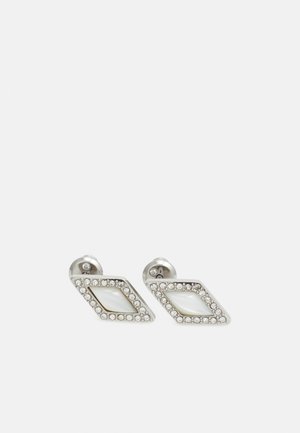Paire de boucles d'oreilles en argent en forme de losange avec un centre blanc et de petits cristaux clairs délimitant les bords.