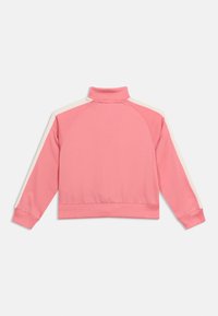 Ροζ φούτερ με μακριά μανίκια, υψηλό γιακά και λευκές ρίγες στο πάνω μέρος των μανικιών, εμφανιζόμενο από πίσω.