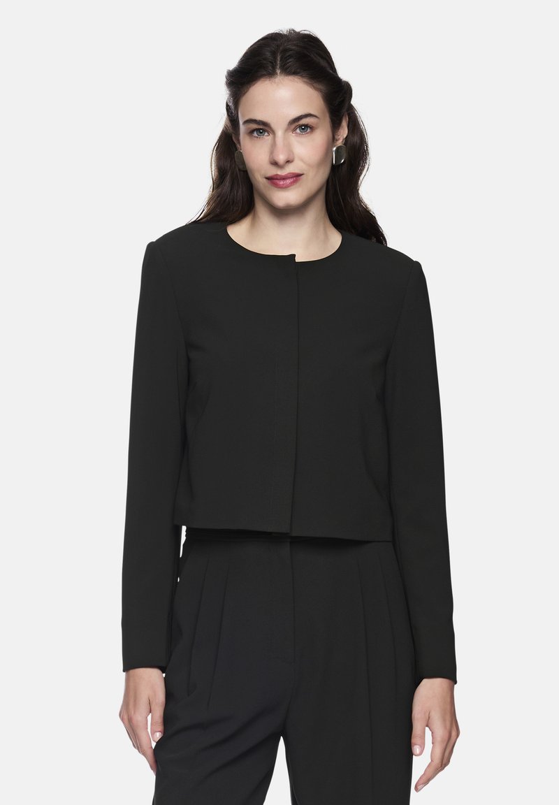 Black cropped jacket with long sleeves, round neckline, and front clasp detail. Made of smooth fabric with a structured shape.