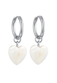 Boucles d'oreilles en argent avec des pendentifs en forme de cœur blancs. Les cœurs ont une finition lisse et brillante, mettant en valeur une texture nacrée subtile.
