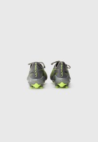 Scarpe da calcio grigie e gialle. Presentano una tomaia testurizzata, con un distintivo logo "ULTRA" sul tallone e tacchetti a forma di stella sulla suola.