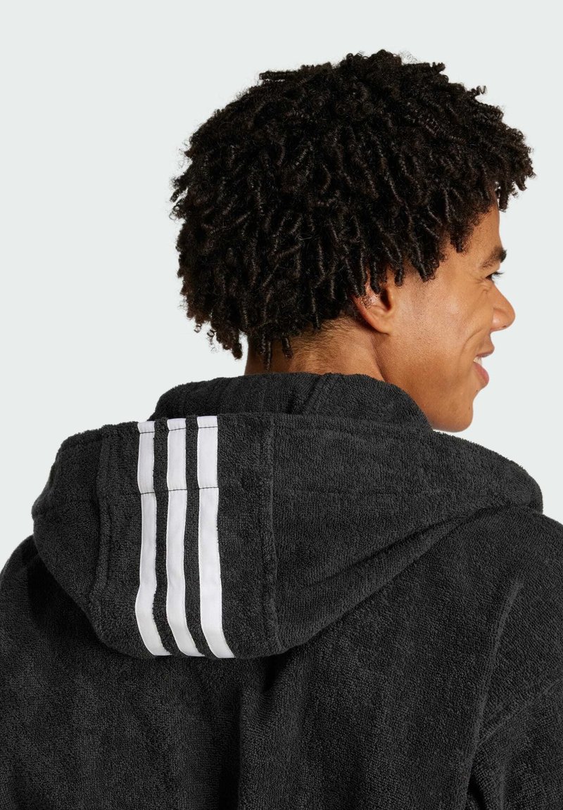 Black terry cloth hooded robe with white three-stripe design on the back. Features a soft texture and a relaxed fit.