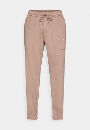 Ανοιχτό καφέ παντελόνι τύπου jogger με ελαστική μέση και κορδόνι. Διαθέτει πλαϊνές τσέπες και μικρό λογότυπο στο αριστερό πόδι. Λείο ύφασμα.