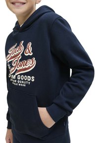 Hoodie bleu marine en coton doux avec une poche kangourou, arborant un texte de logo blanc et rouge sur le devant et des poignets côtelés.