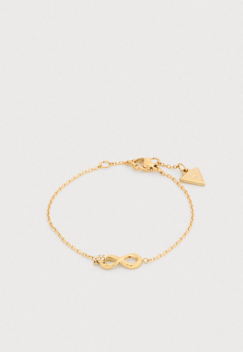 Χρυσό βραχιόλι αλυσίδας με σύμβολο απειρότητας με μικρό διαυγή πολύτιμο λίθο, ασφαλές κούμπωμα τύπου αστακού και τρίγωνο διακοσμητικό στοιχείο.