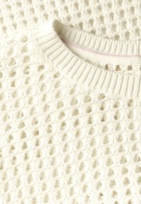 Weißer Strickpullover mit offenem Webmuster und geripptem Kragen. Zu den Details gehört eine subtile rosa Naht im Kragen.