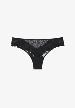 Tanga in pizzo nero con parte frontale trasparente e motivo floreale, retro nero solido e vita elastica. Texture complessiva liscia.