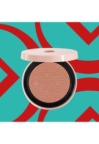 Kompaktes Rouge mit einem hellrosa Deckel und schwarzer Basis. Das gemusterte Pfirsichpuder im Inneren zeigt ein Logo-Design. Der Hintergrund ist türkis mit roten Kurven.