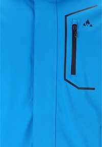 Blå jacka med en dragkedjeförsedd ficka och svarta geometriska detaljer. Tillverkad av smidigt, lättviktigt tyg med sömdekorationer.