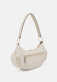 Sac à épaule en nylon beige avec quincaillerie dorée, de forme courbée, doté de poches zippées et d'une bandoulière amovible, avec une texture lisse et des bords arrondis.