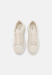 Beige Sneakers mit einer glatten, strukturierten Oberseite, runder Zehenpartie und sechs Ösen. Merkmale ein minimalistisches Design und eine gebrandete Innensohle.