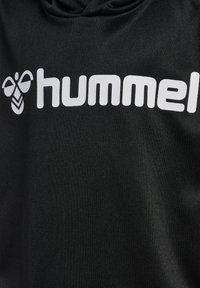 Schwarzer Hoodie mit einer glatten Textur, der ein auffälliges, weißes "hummel"-Logo und ein stilisiertes Bienenmuster auf der linken Seite zeigt.