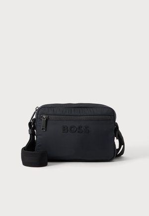 Čierna obdĺžniková crossbody taška s predným vreckom na zips a vyrazeným logom BOSS, so nastaviteľným ramenným popruhom.