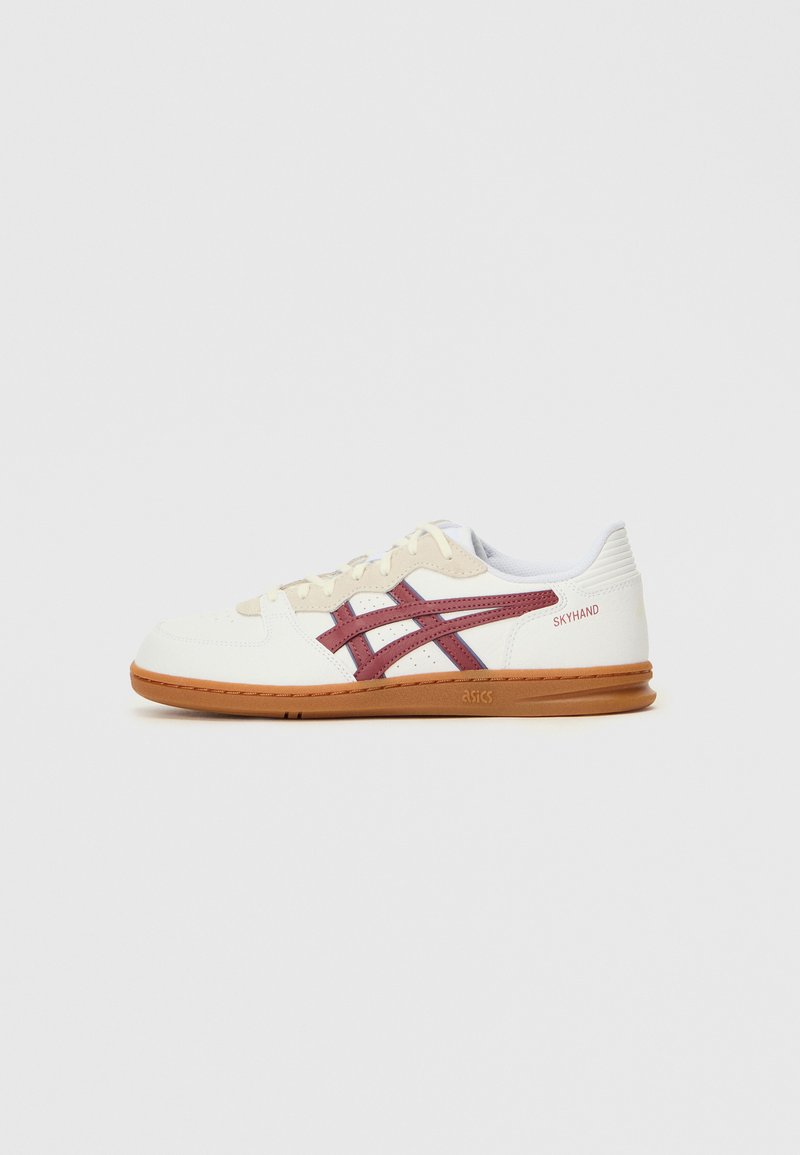 Sko med hvit lær overdel, beige detaljer, maroon logo og striper, gummikse såle, og en teksturert hælkappe. Modellenavn: SKYHAND.