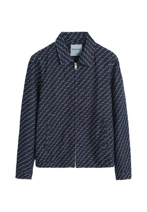 Veste zippée bleu marine avec des rayures blanches ondulées en diagonale, col pointu et poches latérales.