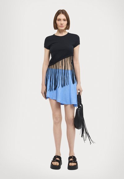 Fekete crop top frufru részletezéssel, kék harangszoknya, fekete platform szandálok és egy kis fekete táska frufru részletekkel.