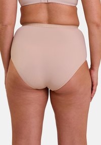 Culottes taille haute beige avec une texture lisse, dotées d'une ceinture élastique douce et sans coutures visibles. Conçues pour le confort et la couvrance.
