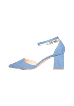 Scarpa alta in denim blu con punta affusolata, cinturino alla caviglia e tacco spesso. Texture liscia con un'apertura sul lato.