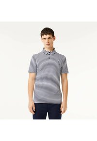 Marinblå och vitrandig polo skjorta med krage och tre knappar. Har en liten grön logotyp på vänster bröst. Slät bomullsmaterial.