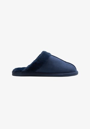 Zapatilla de color azul marino con un forro suave y peludo y un exterior liso. Presenta un diseño de fácil puesta y una punta redondeada para mayor comodidad.