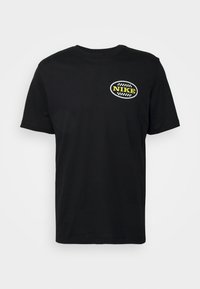 T-shirt en coton noir à manches courtes et col rond, avec un logo imprimé rond en jaune et blanc sur la poitrine gauche.